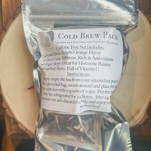 May include: A silver pouch with a white label that reads "COLD BREW PACK" and lists the ingredients and instructions for making cold brew tea. The pouch contains a mix of dried fruit and herbs.