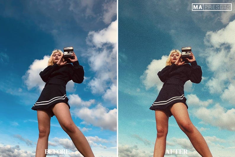 May include: A woman wearing a black skirt with white stripes and a black top, holding a vintage camera, poses against a blue sky with white clouds.