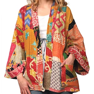 以下が含まれることがあります： 赤い、オレンジ、黄色、青、緑の色合いの様々な生地で作られた、カラフルなパッチワークのキルトジャケット。ジャケットはゆったりとしたフィット感で、広く流れるようなシルエットです。