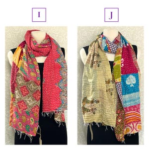 K&ouml;nnte beinhalten: Zwei farbenfrohe Schals werden gezeigt. Der linke Schal ist haupts&auml;chlich rosa mit Patchwork-Mustern in verschiedenen Farben. Der rechte Schal ist beige mit einem Muster aus Figuren und Patchwork in mehreren Farben. Beide Schals sind &uuml;ber einer schwarzen Form drapiert.
