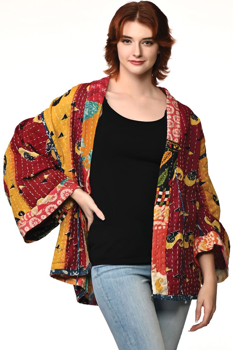 A vibrant patchwork kimono-style jacket featuring a fun mix of colors and patterns, including bright tones with floral, geometric, and abstract designs. The jacket has wide sleeves, a relaxed fit, and visible hand-stitching, creating a boho look.