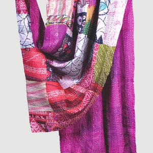 May include: A rectangular textile piece featuring a patchwork design of various fabric scraps in shades of magenta, pink, red, and white. The fabric is held together by visible white running stitches throughout, creating a textured, quilted appearance.