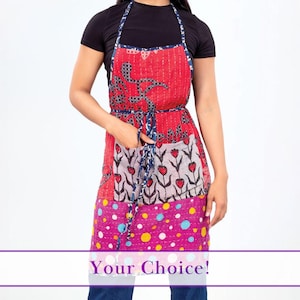 Puede incluir: Un delantal de patchwork con una sección superior roja con un diseño geométrico, una sección media con patrones florales y de corazón y una sección inferior con lunares. El delantal tiene una corbata estampada azul y blanca y el texto "Your Choice!"