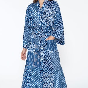 May include: A blue and white patterned robe with a long sleeve and a sash tie. The robe has a patchwork design with various geometric and floral patterns.