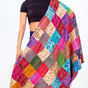 May include: A large rectangular shawl featuring a vibrant patchwork design composed of numerous square fabric panels in various colours including magenta, turquoise, green, yellow, and cream, each decorated with intricate floral and geometric patterns.