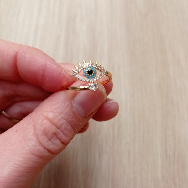 Bague femme oeil bleu strass acier inoxydable doré ajustable.