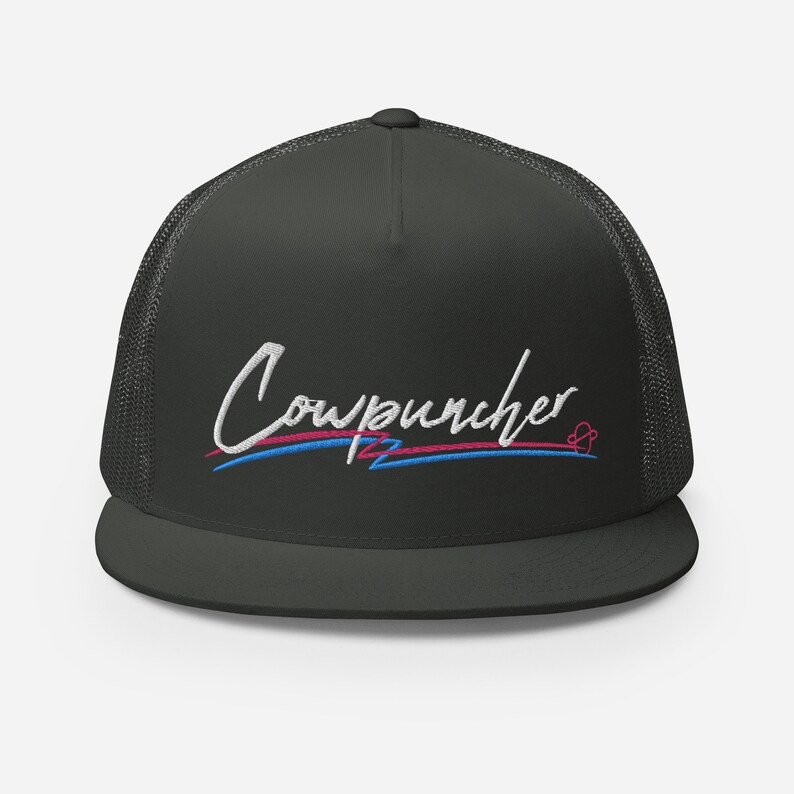 Pu&ograve; includere: Cappellino da camionista grigio scuro con retro in rete e visiera piatta. Il cappello presenta la scritta ricamata "Cowpuncher" in corsivo bianco, con linee blu e rosa sottostanti. Un piccolo disegno a forma di cuore &egrave; a destra.