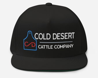 Puede incluir: Gorra de béisbol negra con un logotipo bordado en blanco que dice "COLD DESERT CATTLE COMPANY". El logotipo presenta una etiqueta de oreja roja y azul con las letras "CD" en su interior.