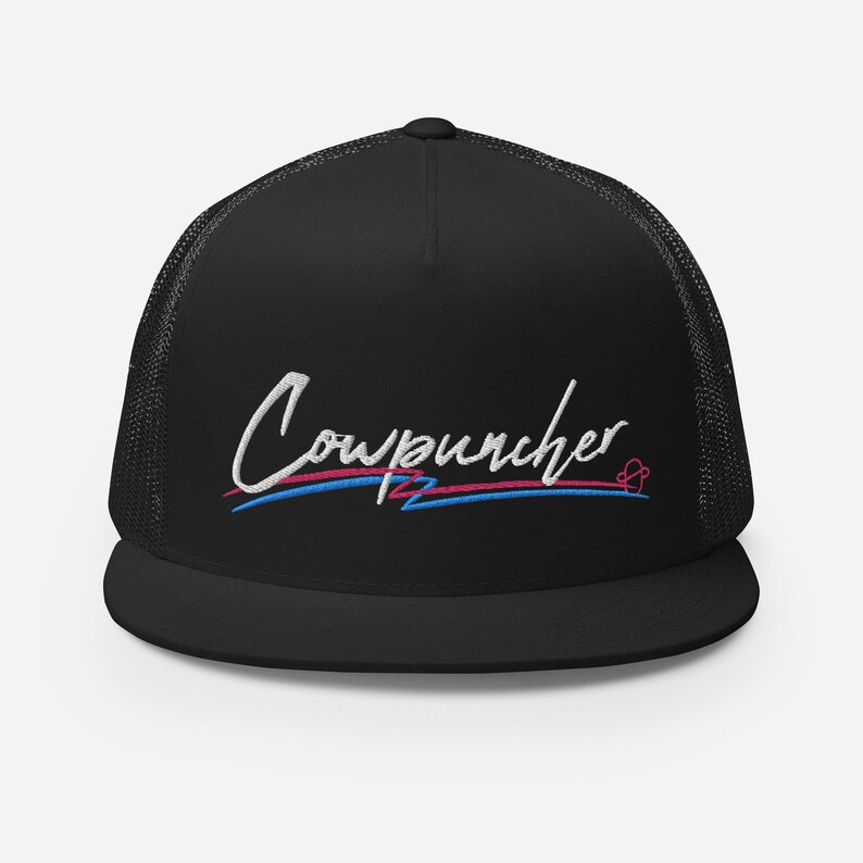 Pu&ograve; includere: Cappellino da camionista nero con retro in rete e visiera piatta. Il cappello presenta la scritta ricamata "Cowpuncher 12" in corsivo bianco, con accenti blu e rosa. Un disegno a forma di cuore &egrave; accanto al testo.