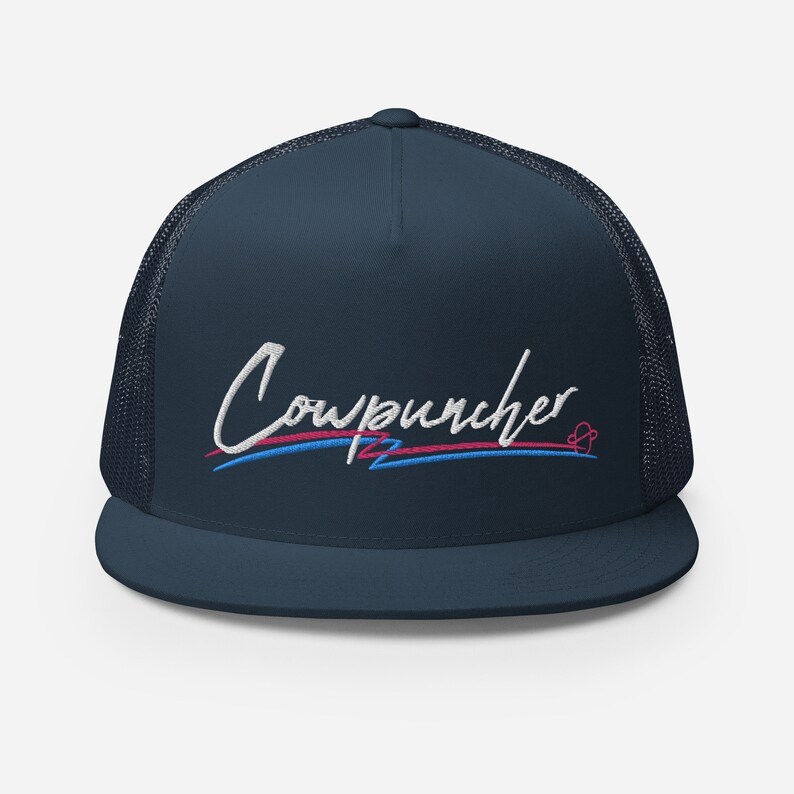 Pu&ograve; includere: Cappellino da camionista blu navy con retro in rete e visiera piatta. Il cappello presenta la scritta ricamata "Cowpuncher" in corsivo bianco, con linee di accento blu e rosa. Un piccolo disegno a forma di cuore &egrave; sul lato destro.