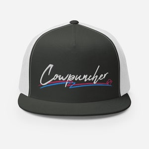 Pu&ograve; includere: Cappellino da camionista nero e bianco con la scritta "Cowpuncher" ricamata in corsivo bianco. Il testo &egrave; sottolineato da linee blu e rosa. Il cappellino ha una visiera curva e un retro in rete.