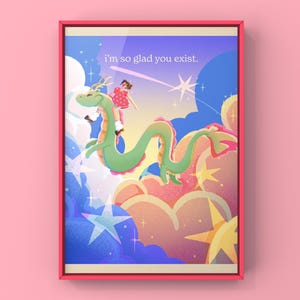 May include: Framed art print featuring a whimsical illustration of a green dragon with a girl in a red dress riding it through a colorful sky filled with stars and clouds. The text "i'm so glad you exist" is displayed at the top.