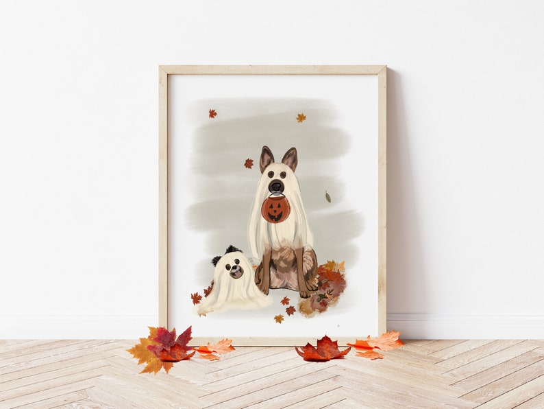 Pu&ograve; includere: Due cani vestiti da fantasmi per Halloween. Il cane pi&ugrave; grande tiene una piccola zucca arancione. I cani sono seduti su un letto di foglie autunnali.