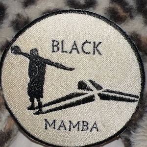 May include: Black and white embroidered patch with a basketball player silhouette and the words "BLACK MAMBA".