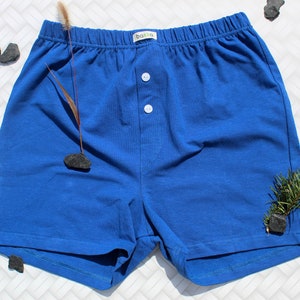 Puede incluir: Pantalones cortos tipo bóxer de color azul brillante con bragueta abotonada. Los pantalones cortos tienen una cintura elástica y una pequeña etiqueta con la marca "bakka". Fabricados con un material suave y cómodo.