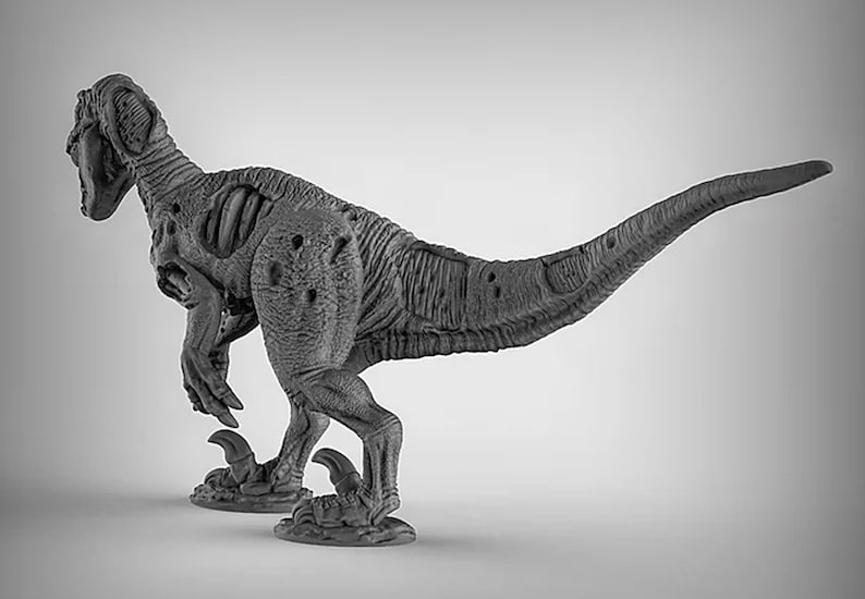 May include: A gray, detailed, plastic dinosaur figurine with a textured surface. The dinosaur is posed in a running position with its head turned to the side.
