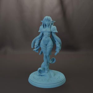 May include: A light blue figurine of a female elf with long hair, pointed ears, and armor-like shoulder pads. The elf is standing on a decorative base with a swirling design. The figurine is a solid color and appears to be made of resin.