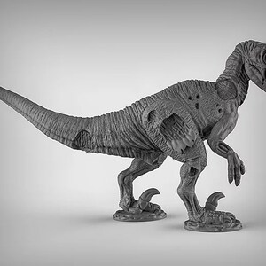 May include: A gray, detailed, plastic miniature of a dinosaur, a velociraptor, with a damaged, skeletal appearance. The dinosaur is posed in a walking stance with its head turned to the side.