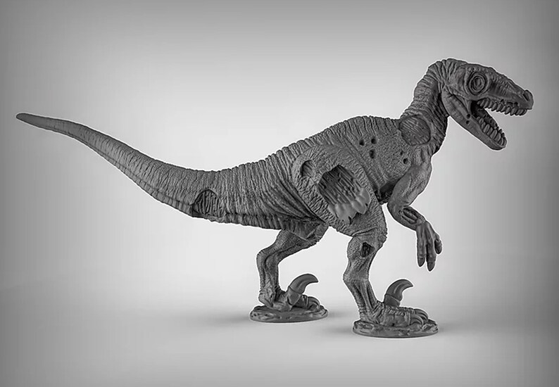 May include: A gray, detailed, plastic miniature of a dinosaur, a velociraptor, with a damaged, skeletal appearance. The dinosaur is posed in a walking stance with its head turned to the side.