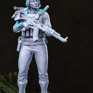 Peut inclure: Une figurine en plastique grise d'une personne portant un uniforme militaire et tenant un fusil. La figurine est debout sur une base grise.
