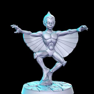 Puede incluir: Una figurita pintada de blanco de una figura humanoide con alas, de pie sobre una base de piedra. La figura tiene una cabeza puntiaguda y está en pose con los brazos extendidos.