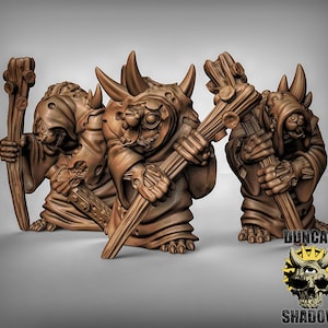 May include: Three brown painted miniature figurines of fantasy creatures holding wooden staffs. The figures are wearing robes and have detailed faces.