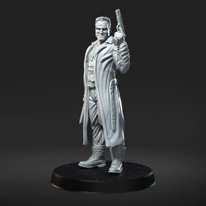 May include: A gray figurine of a man in a long coat, holding a gun. The figure is standing on a black circular base. The coat is open, revealing a shirt and tie. The figure is wearing boots.
