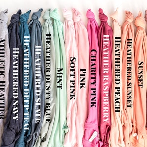 May include: A variety of t-shirt colors, including black, white, ash, heather navy, heather teal, heather slate, heather dusty blue, mint, soft pink, pink, charity pink, heather raspberry, heather peach, heather sunset, sunset, mauve, heather mauve, heather orchid, heather maroon, and maroon.