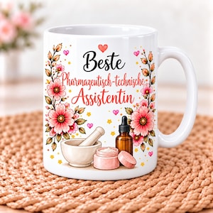 Könnte beinhalten: Ein weißer Keramikbecher mit dem Text "Beste Pharmazeutisch-technische Assistentin" in schwarzer und roter Schrift. Das Design zeigt rosa Blumenranken, einen Mörser mit Stößel, eine kleine braune Tropfflasche und einen rosa Kosmetiktiegel.