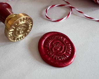 May include: A red wax seal with the words "North Pole Official" in gold lettering. The seal is imprinted with a Santa Claus design.