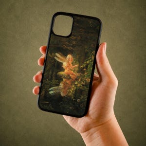 May include: A black phone case featuring a detailed illustration of a winged fairy sitting on a mushroom in a dark, lush forest setting. The artwork displays warm golden tones on the fairy contrasting with the deep green and brown foliage background.
