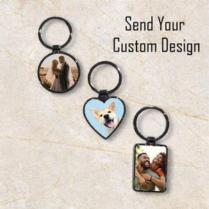 May include: Three keyrings with custom designs and black metal rings. One is round with a wedding photo, another is heart-shaped with a dog, and the last is rectangular with a couple. The text "Send Your Custom Design" is visible.