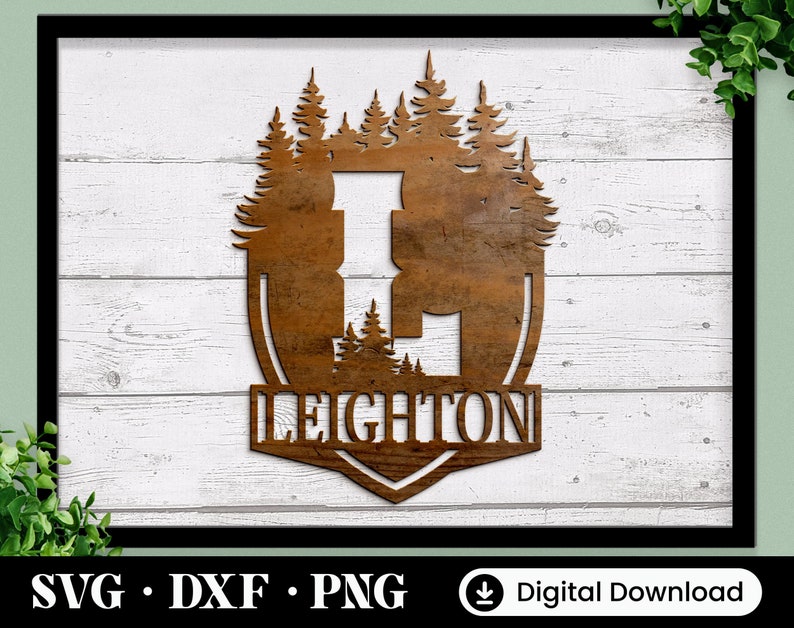 Puede incluir: Un letrero de madera marr&oacute;n con una silueta de un bosque y la palabra "LEIGHTON" en una fuente decorativa.