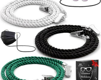 May include: Three pairs of glasses holders, one white, one black, and one green. Each holder has two clips and a twisted rope design. The image also includes a black face mask with a black cord and a small image of a gift box with the text "SG Glasses Holders Special Collection".