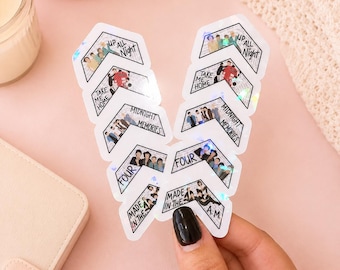 May include: Two vertical columns of chevron-shaped stickers featuring illustrations of a musical group. Each sticker displays an album title: Up All Night, Take Me Home, Midnight Memories, Four, and Made in the A.M. The stickers have a holographic finish.
