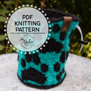 May include: A black and teal knitted drawstring bag with a leather patch that says "M". The bag is sitting on a gray surface. The text "PDF Knitting Pattern the Maker lifestyle" is on a white circle with a dotted border.