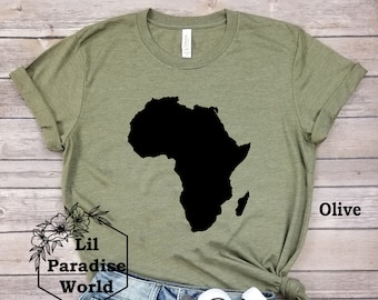 May include: Olive green t-shirt with a black silhouette of the continent of Africa. The shirt is paired with denim shorts and black canvas sneakers. The text "Lil Paradise World" is visible in the lower left corner of the image.