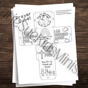 Puede incluir: Un cubo de oración imprimible en blanco y negro con instrucciones para cortar, doblar y pegar. El cubo tiene seis lados con diferentes indicaciones de oración, incluyendo "¡Reza por el mundo!" y "Lo siento por..."