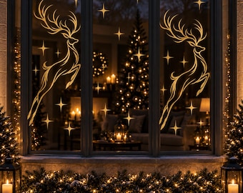 May include: A set of gold-colored window decals featuring two leaping reindeer with large antlers and multiple four-pointed star shapes. The decals are applied to a multi-pane window, with a blurred interior view of a lit Christmas tree.