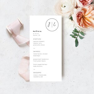 Peut inclure: Un menu de mariage avec la date 01.25.22 et l'emplacement Denver, CO. Le menu comprend des entrées, des plats principaux et des desserts. Le haut du menu comporte un cercle avec les initiales J & E.