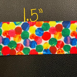 May include: A 1.5 inch wide ribbon with a colorful polka dot pattern. The dots are red, yellow, blue, green, orange, and purple on a white background.