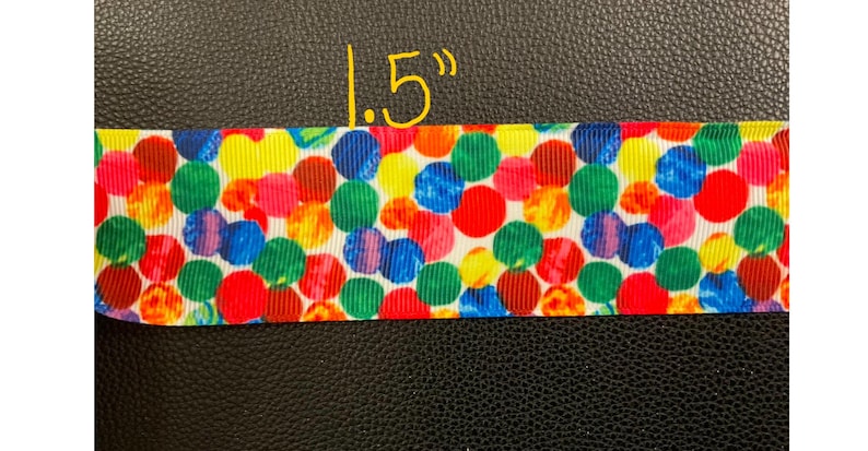 May include: A 1.5 inch wide ribbon with a colorful polka dot pattern. The dots are red, yellow, blue, green, orange, and purple on a white background.