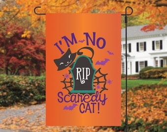 May include: Orange Halloween garden flag with a black cat, a tombstone that says "RIP", and the text "I'm No Scaredy Cat!" in purple and green lettering.