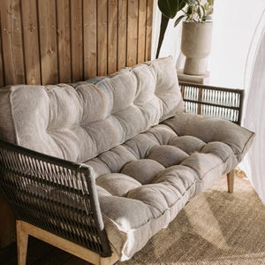 Cream white outdoor cushion set on a bench, featuring a bottom seat cushion and matching backrest in French mattress style. Made from high-quality EU-produced bouclé-like fabric suitable for outdoor use. The material is water-repellent but not fully waterproof and can get wet occasionally. Also suitable for indoor spaces. Perfect for modern Scandinavian homes, A-frame houses, Portuguese terraces and bohemian Spanish villas.