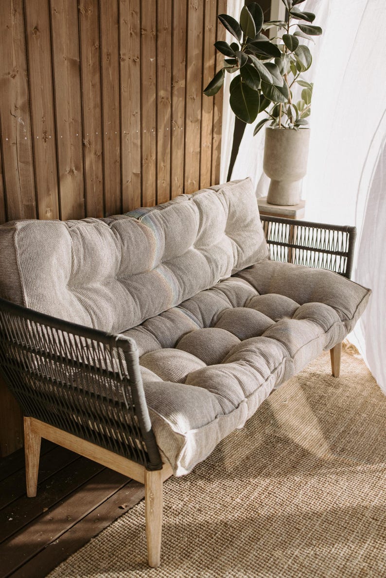 Cream white outdoor cushion set on a bench, featuring a bottom seat cushion and matching backrest in French mattress style. Made from high-quality EU-produced bouclé-like fabric suitable for outdoor use. The material is water-repellent but not fully waterproof and can get wet occasionally. Also suitable for indoor spaces. Perfect for modern Scandinavian homes, A-frame houses, Portuguese terraces and bohemian Spanish villas.