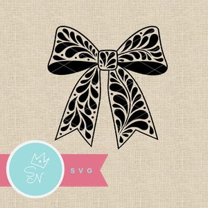 May include: Black decorative bow with a detailed floral design. The bow features a central knot and two flowing tails, all with a symmetrical pattern. The image includes a logo with the text "SVG".
