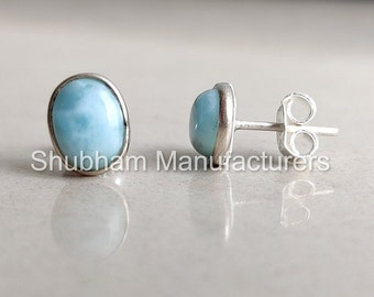 May include: A pair of silver stud earrings with oval-shaped blue and white gemstone settings.