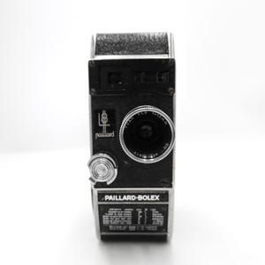 Puede incluir: Una cámara de cine Paillard-Bolex de 8 mm negra y plateada con una lente Yvar 1:1.9 f=13 mm. La cámara tiene una perilla plateada en el lateral y una inscripción plateada que dice "Paillard-Bolex".