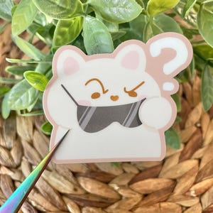 May include: White cartoon character with a question mark above its head, wearing sunglasses and looking confused. The character has a pink nose and pink ears.