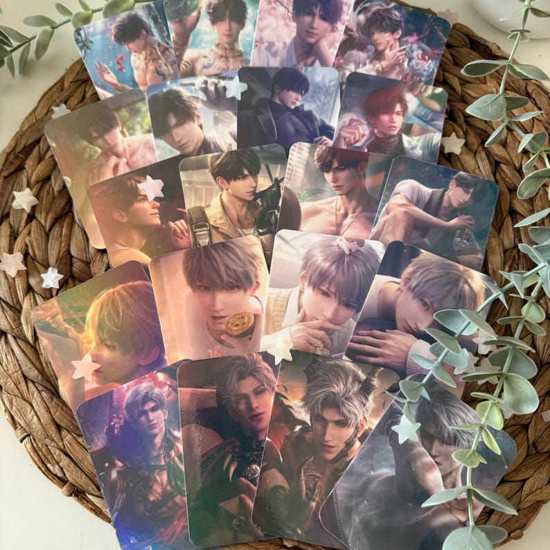 May include: A collection of rectangular trading cards featuring various anime-style male characters with diverse hair colors and expressions, arranged in an overlapping fan pattern on a woven circular mat with small white star-shaped accents.